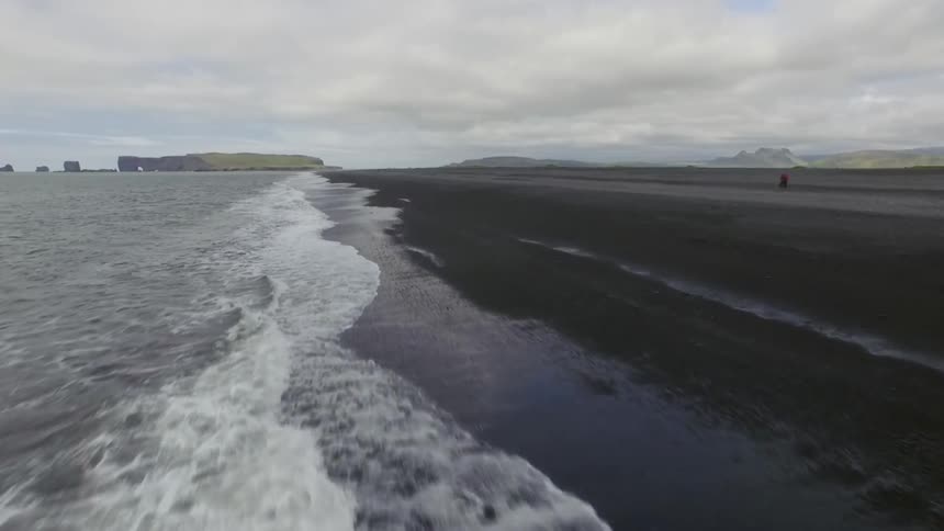 Waves crash into the shoreline on a cloudy day