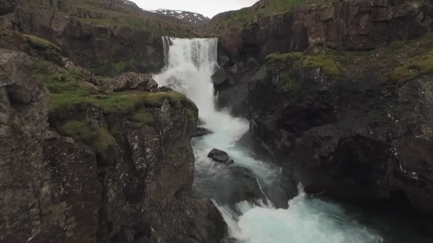 Water rushes down a waterfall and rocky whitewater river amidst the rocks