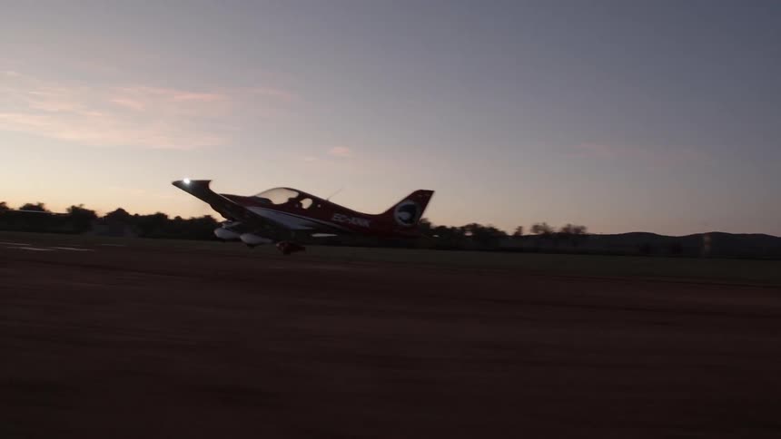 Small airplane takes off at sunset