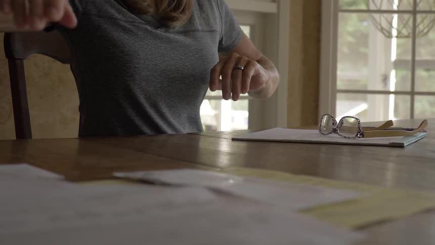 Woman reading documents then angrily shoves them to the side of the table