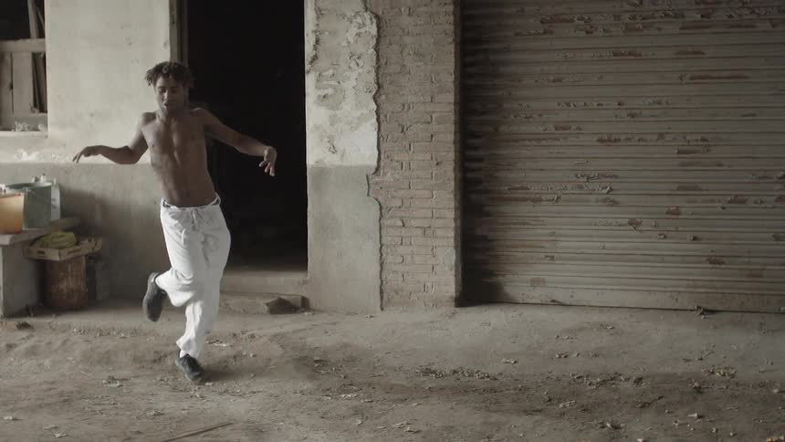 A young boy performs a pop and lock dance routine