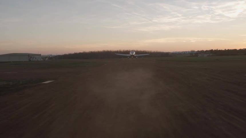 A small plane takes off from a small airport runway