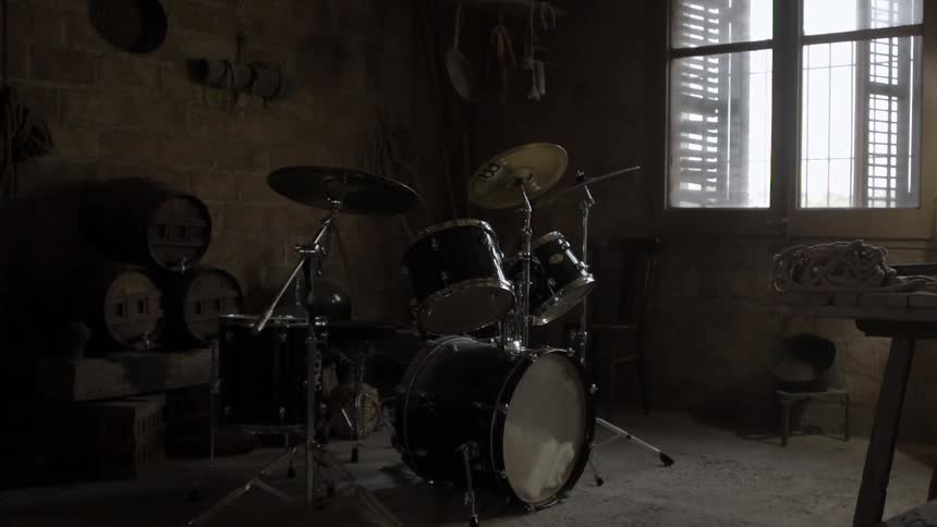 A drum set stands in a garage
