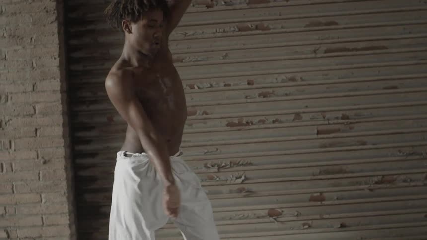 A young man performs a pop and lock dance routine