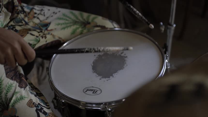 A drummer picks up his sticks and starts to play