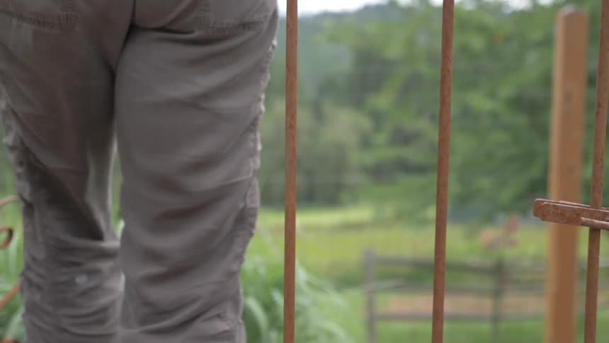Woman opens iron door and gets in during daylight