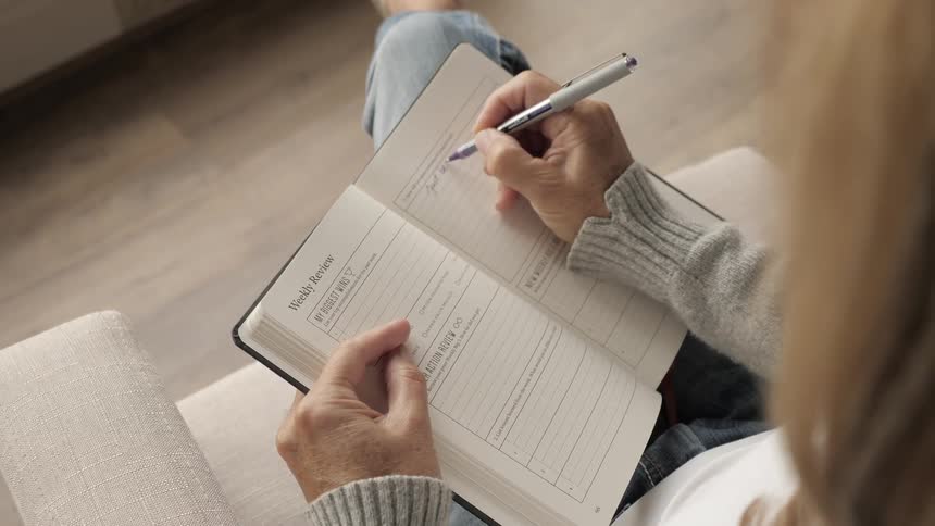 A woman writes an entry into her planner