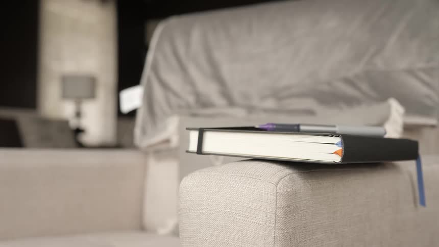 A book rests on the arm of a chair
