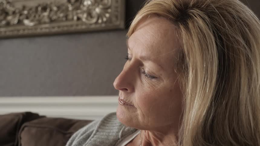 A woman is thinking on the sofa