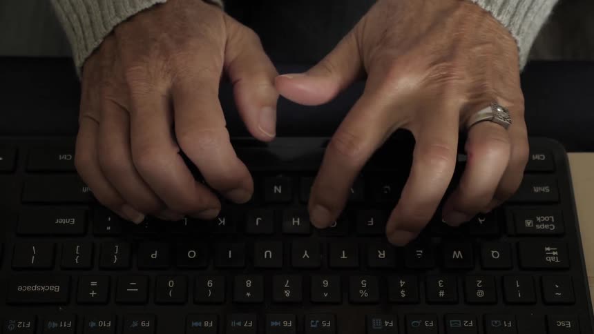 A woman types on a computer keyboard