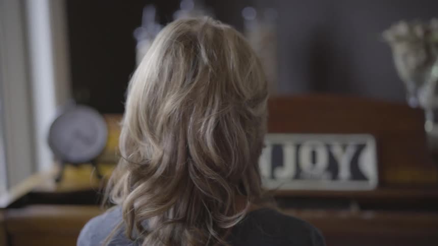 A woman sits and plays the piano
