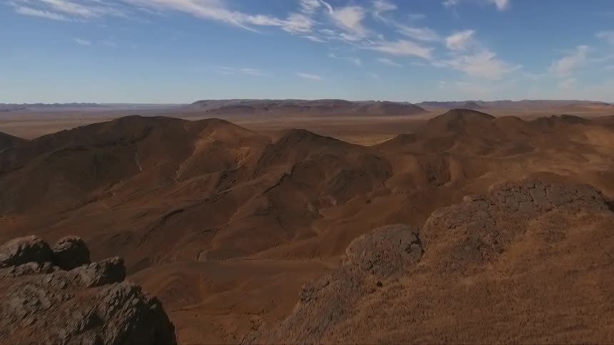 Aerial view of brown, rocky cliffs in a mountainous region