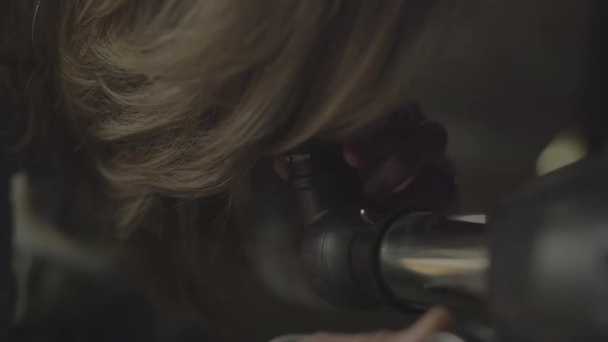 A woman is looking through a telescope