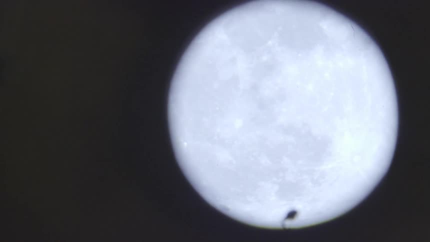 The camera looks at the moon through some kind of magnification