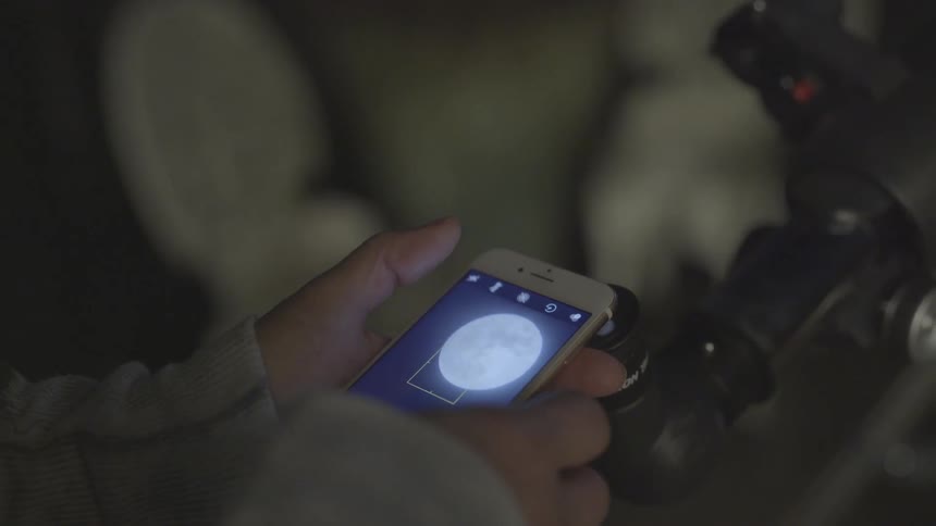 A white person fiddles with their smartphone