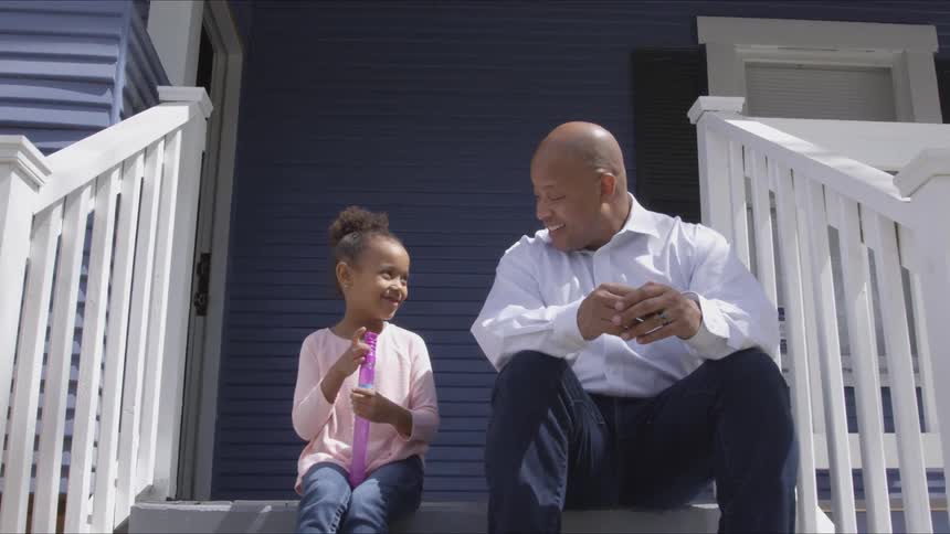 Man and girl sit at the doorstep and talk with each other in the daytime