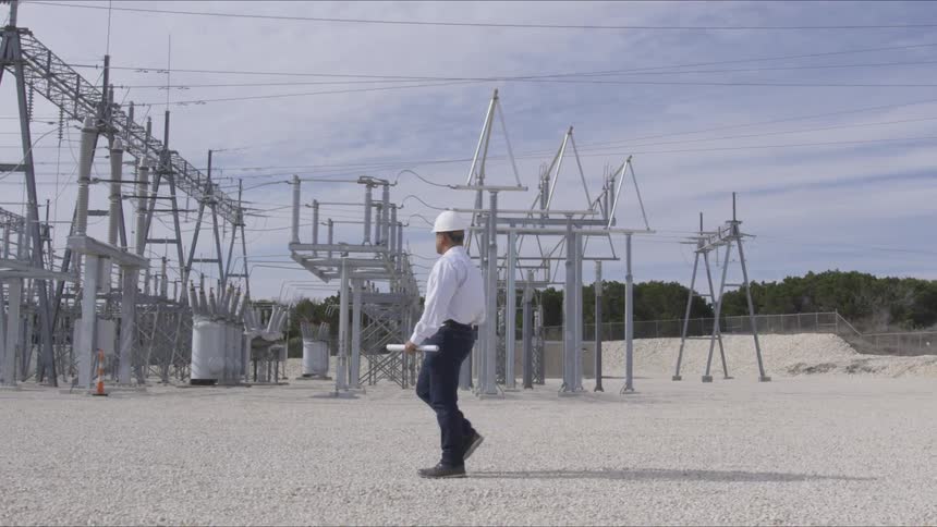 Man walks through electric power substation