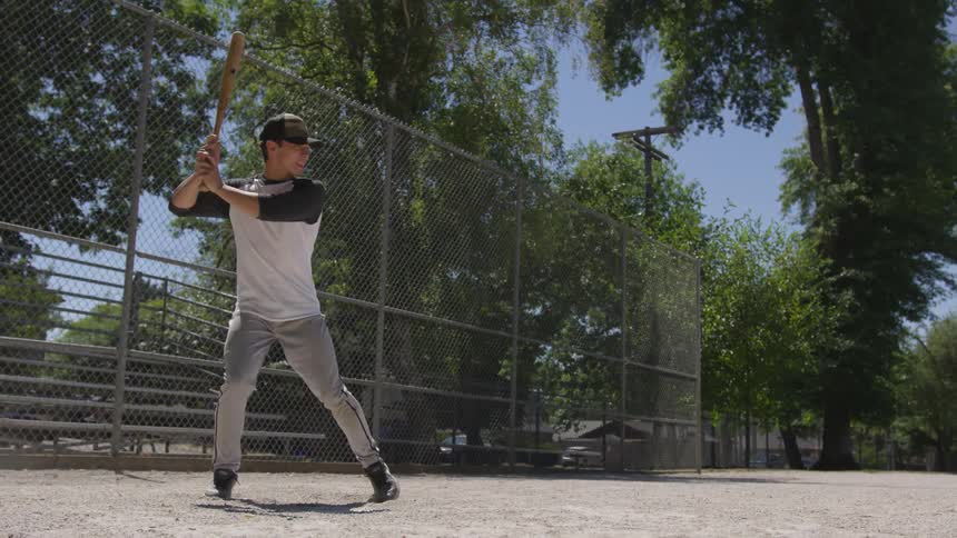 Man practices swinging bat at home plate