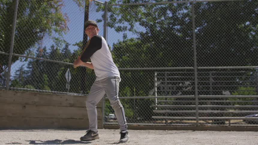 Man tosses baseball and hits it