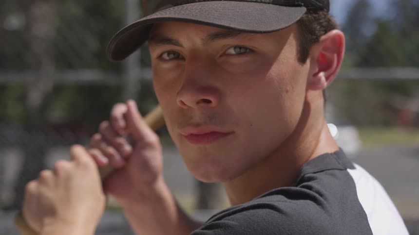 A young man holds the bat for the pitch