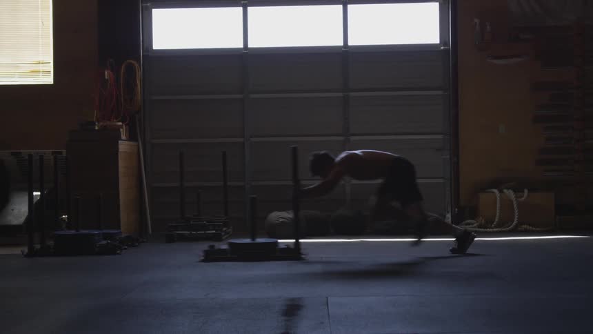 Man trains in darkened gym