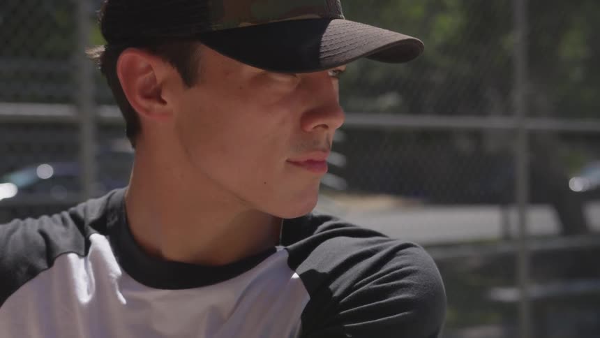 A young man prepares to swing a baseball bat at an incoming pitch