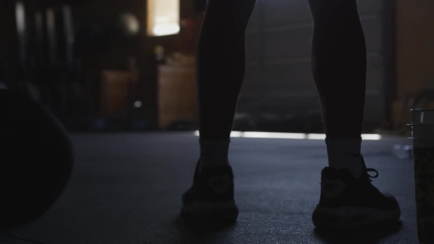 A man wearing sneakers stands in a gym