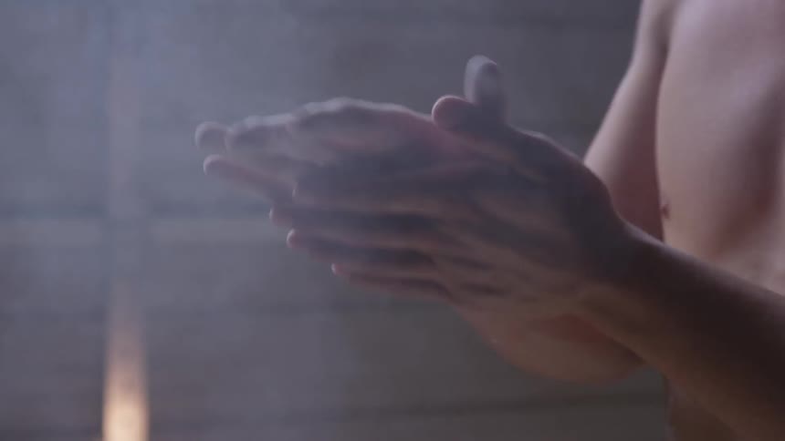 A man claps his hands together with chalk