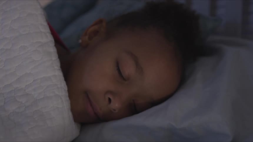 A little girl sleeps in bed