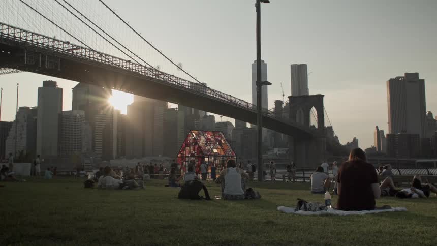 People sit on a grassy lawn in a city