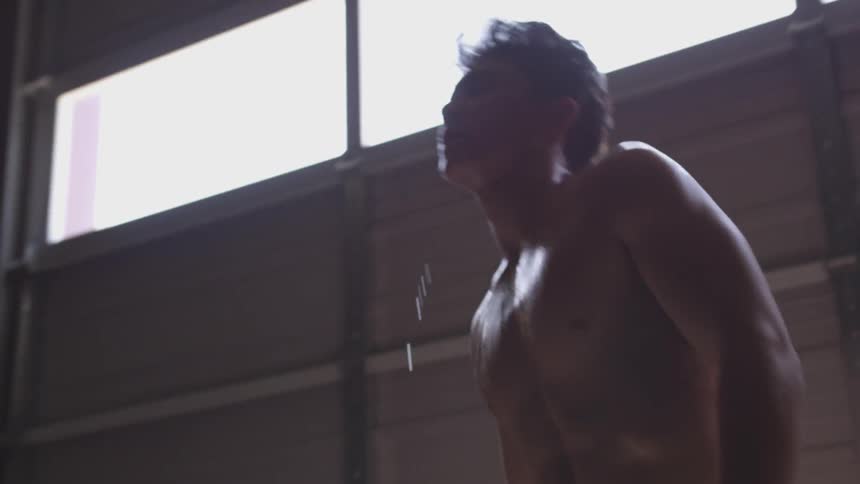 Half naked muscular man breathes deeply indoors during daylight