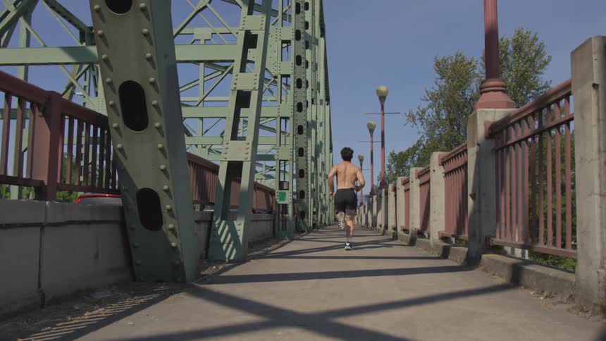 Man runs on bridge next to road