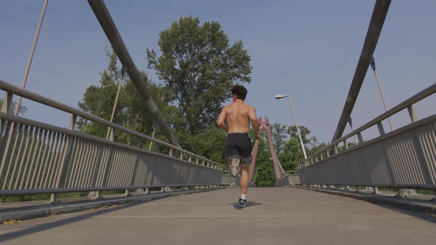 A man runs across a pedestrian bridge