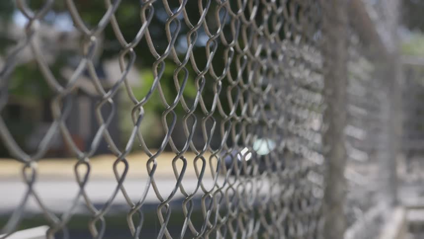 Looking through chain link fence in suburbs