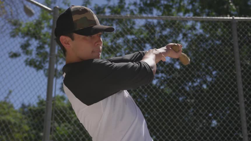 Male hitting a baseball with a bat