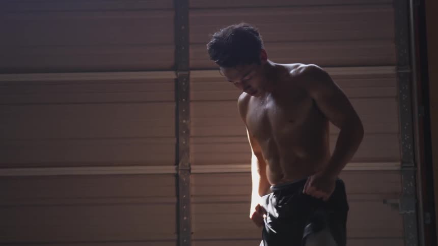 Man stretches and recovers in garage gym