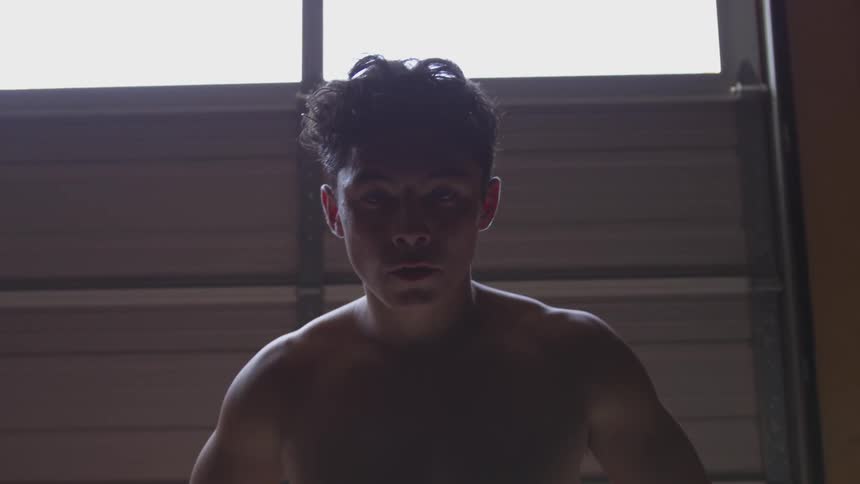 A shirtless white young man catching his breath