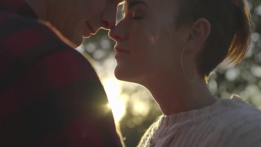 A man and a woman stand closely together nose to nose exuding a sense deep love