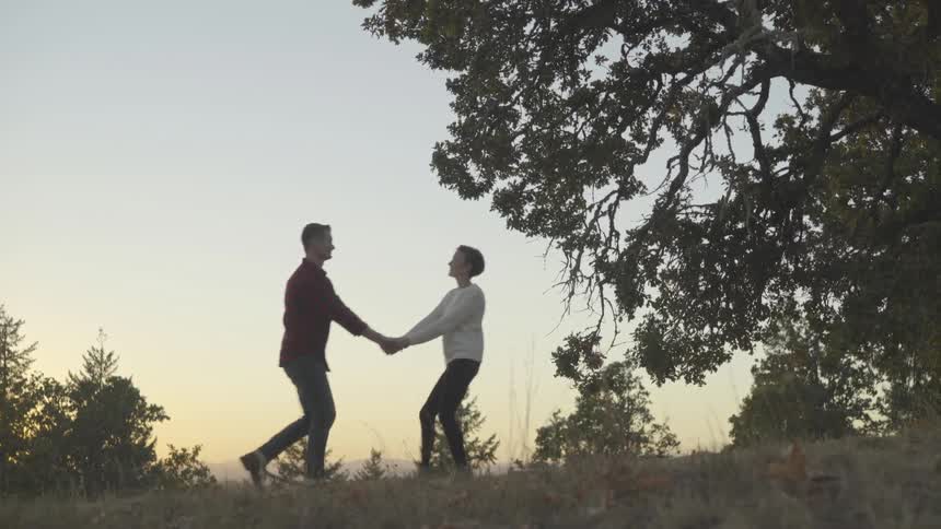 Man and woman hold hands as they walk outdoors