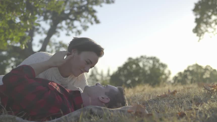 Man and woman lay on blanket in field
