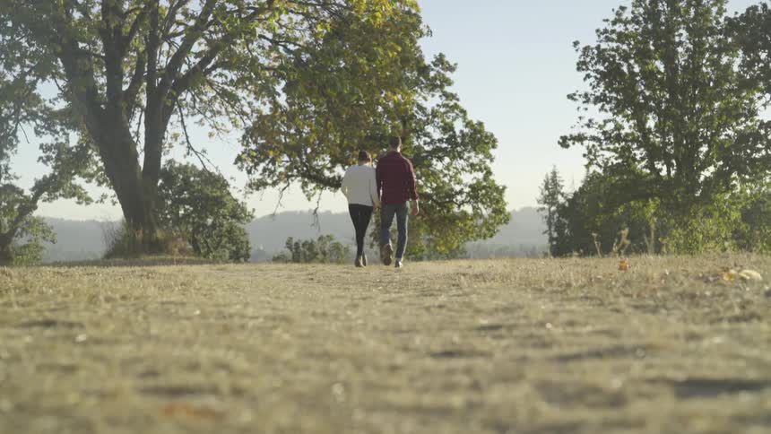 A man and woman walking outside holding hands
