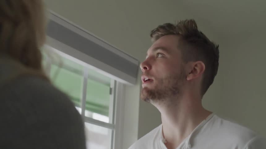 A man and woman use hand gestures while arguing inside a home