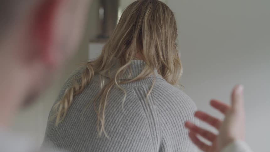 A man talking to a woman who is facing away from him