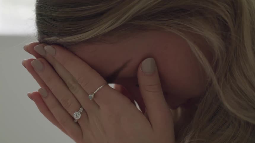 A woman covering her face out of distress