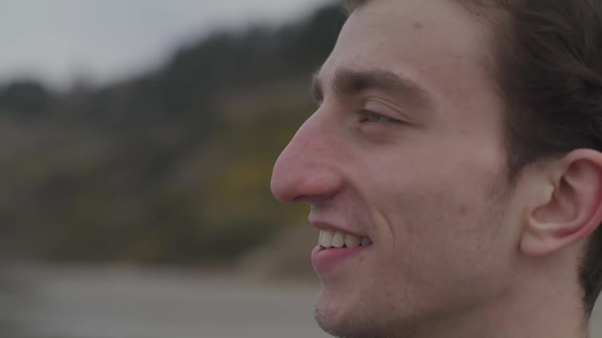 Man stands smiling on the beach