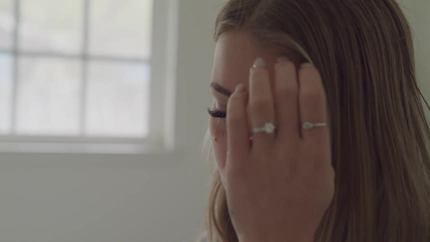 Blonde woman sheds tears indoors during daylight