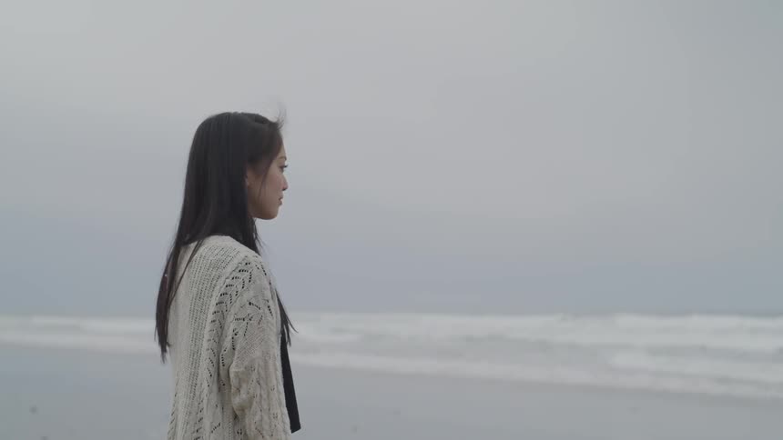 A woman watches the waves of the ocean