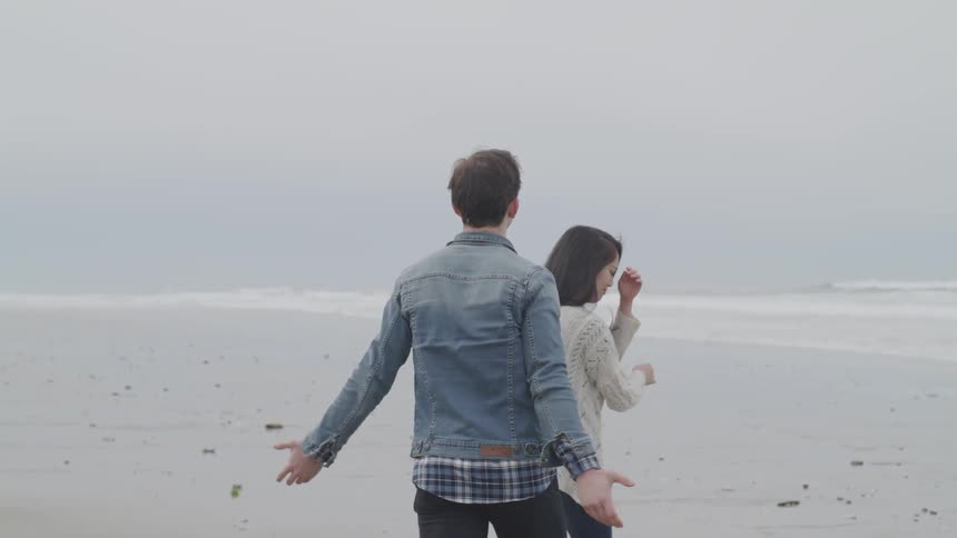 A man tries to console an emotional woman on the beach