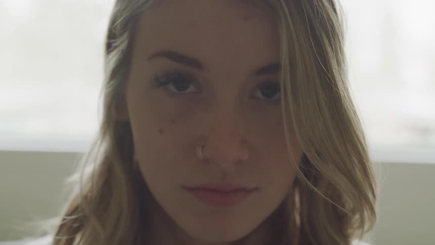 A woman is staring forward blinking