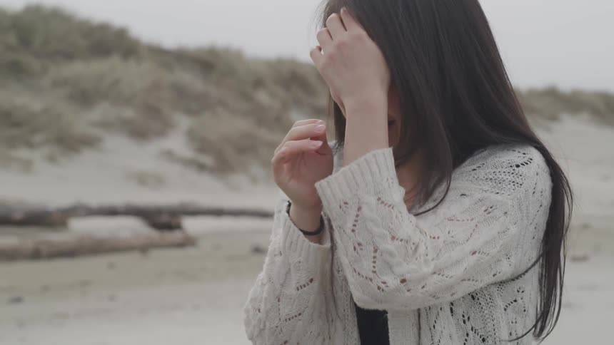 A woman cries on the beach and pushes a man away
